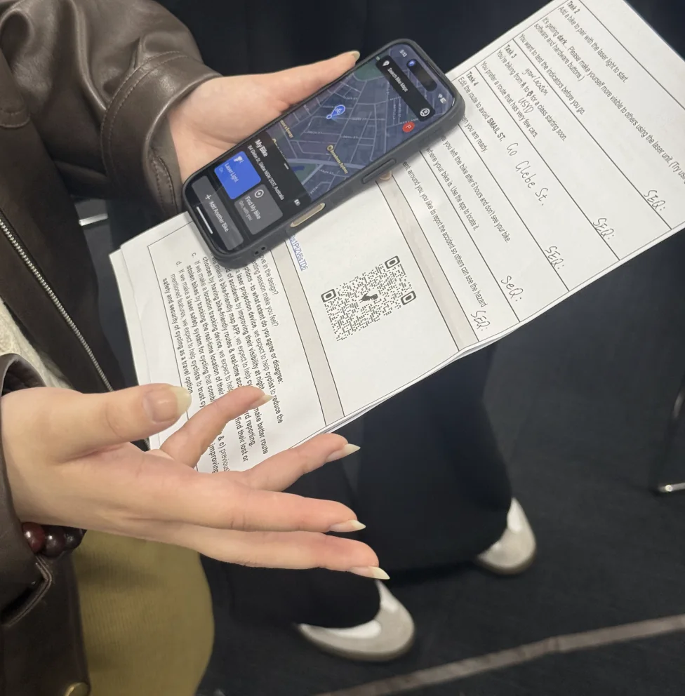 A participant holding the phone prototype above a printed task sheet
