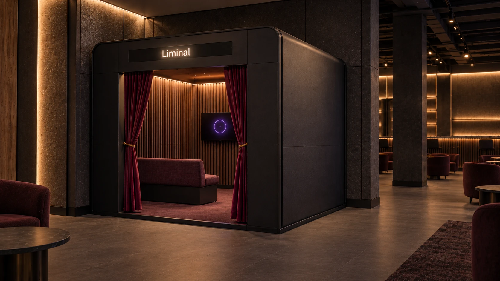 The Liminal booth in a venue lounge: a dark enclosure with a lit sign, tied-back red curtains, a bench and a wall screen glowing violet